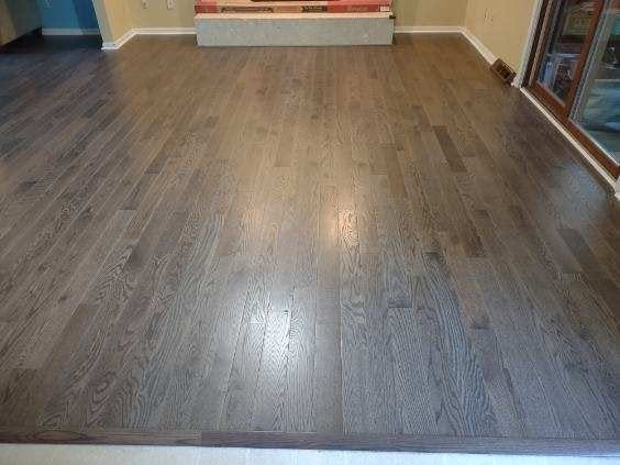 Gray-stained oak plank flooring installed across an open living room